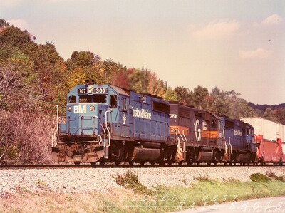 D&H Sea-Land stack train at Dale NY
An ex-D&H GP39-2 in fresh Guilford paint is sandwiched by a pair of blue B&M GP40-2s on a sunny October day as they hustle east through bucolic Dale NY after climbing the torturous hill at Attica.  The arrival of double-stack container trains to both D&H and host Conrail's operating scheme more than doubled the number of daily trains on the ex-EL Southern Tier Line for a period of several years while Conrail tackled clearance problems on the Water Level Route.
Photo Copyright 2008 Tim Baldwin
Keywords: d&h;gp39-2;guilford;b&m;conrail;dale;ny;attica