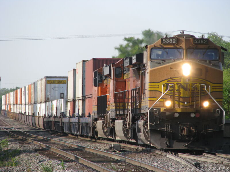 BNSF EB Double Stack
BNSF 5382, 4507 and 7014 on an eastbound domestic stack train at MP 26.10 on the TransCon in Olathe, Kansas on 7/31/2014. Train is headed through the crossovers to change from Mainline 1 to Mainline 2. In 26 more miles the train will be entering the old ATSF Argentine Yard in Kansas City.
Keywords: bnsf;double;stack;53;domestic;kansas;transcon;crossover;argentine