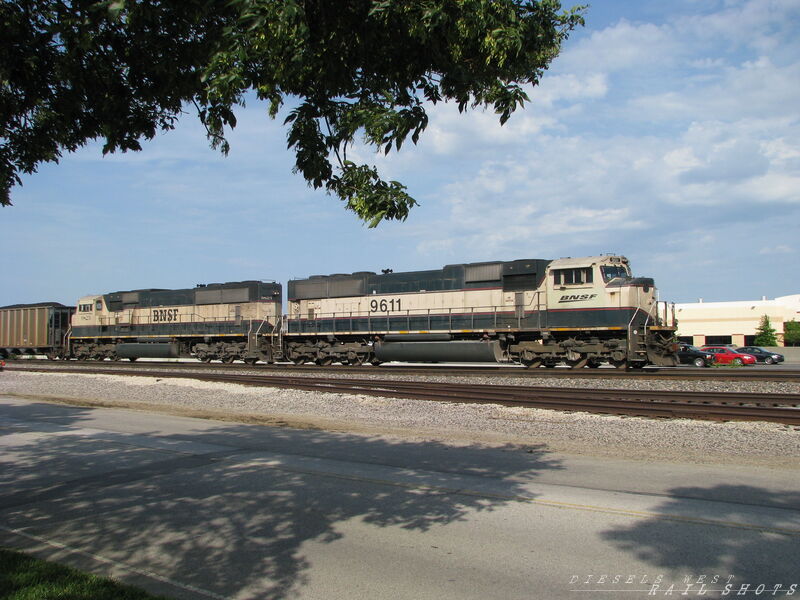 BNSF SB Coal Drag
BNSF 9611 and 9823 lead a loaded UCEX coal train through Lenexa, Kansas on 7/11/2014. The train is slowly coming to a stop at the signals for the Charlie CP. The train will wait here for traffic ahead to clear before proceeding.
Keywords: sd70mac;executive;coal;lenexa;ks;kansas