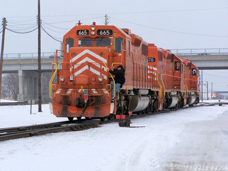 The 'J' at Eola
Conductor Mike Claudillo hops up on the steps of EJ&E 665 as the head west around there coal train to retrieve the FRED from a merchandise train the just delivered and install it on the last car of their new trainset. 
Note the westbound BNSF to the right of the SD38's
Keywords: sd38-2;eola;ej&e;coal;conductor;bnsf